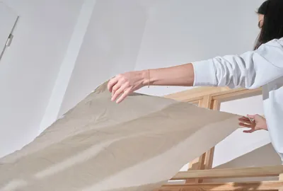 Monika Žáková spreading raw canvas in the studio